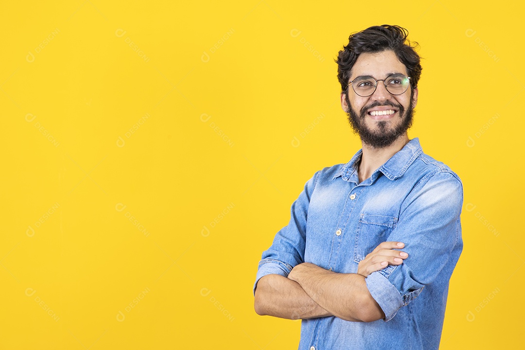 Homem jovem braços cruzado barbudo sobre fundo amarelo