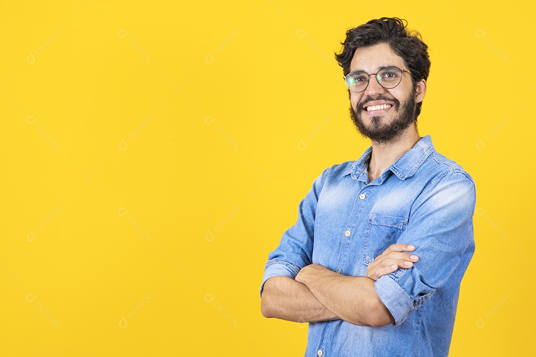 Homem jovem braços cruzado barbudo sobre fundo amarelo