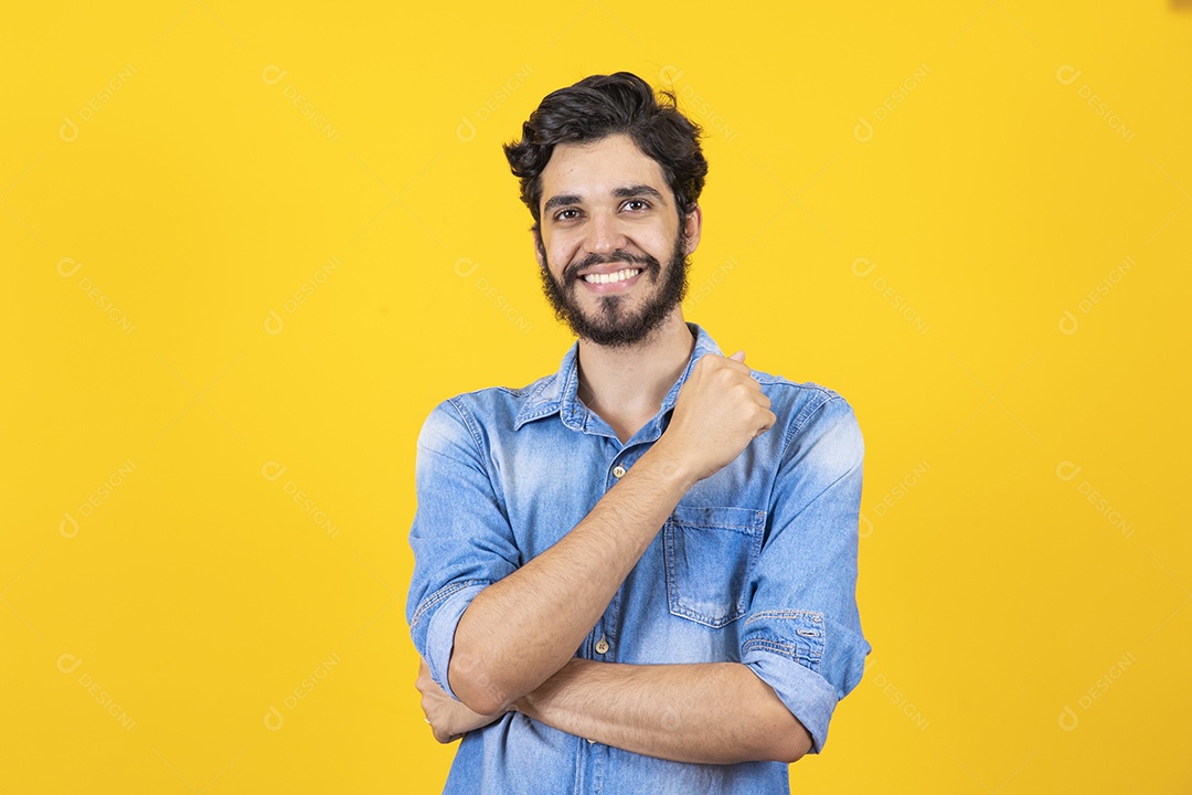 Homem jovem braços cruzado barbudo sobre fundo amarelo