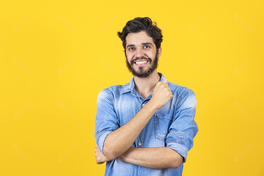Homem jovem braços cruzado barbudo sobre fundo amarelo