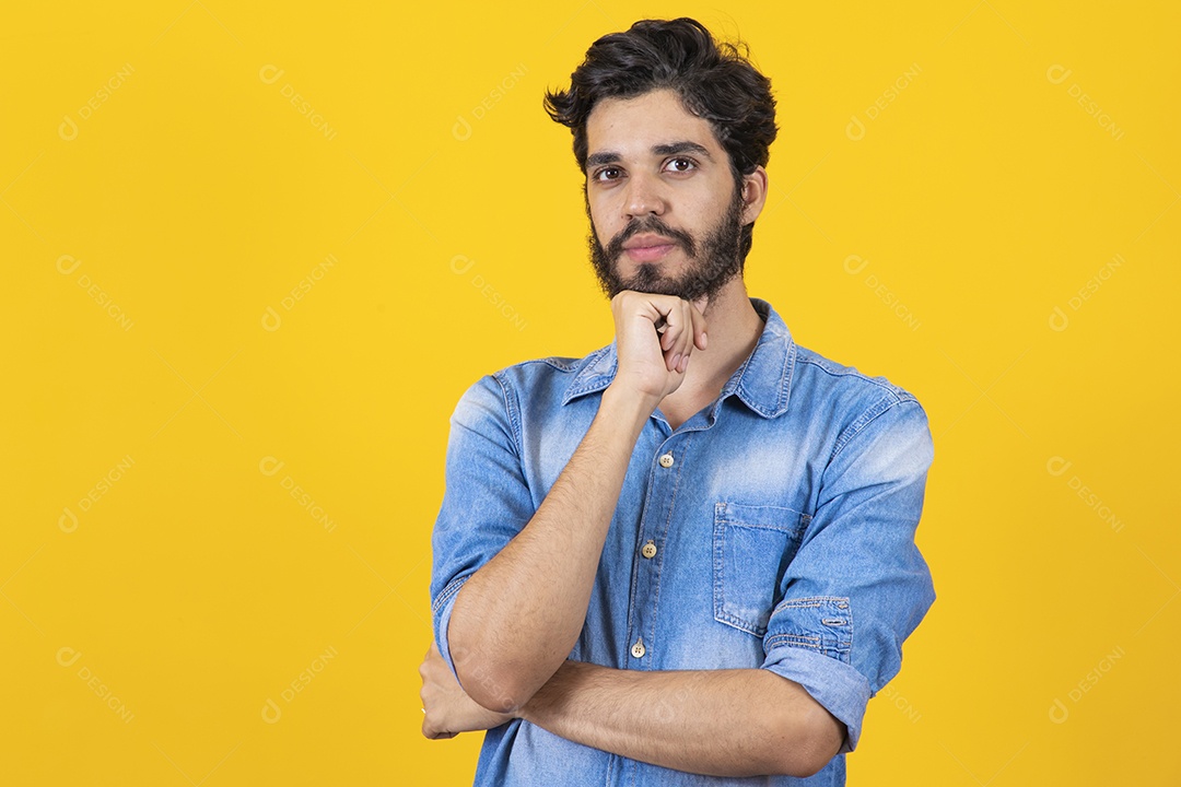 Homem jovem braços cruzado barbudo sobre fundo amarelo