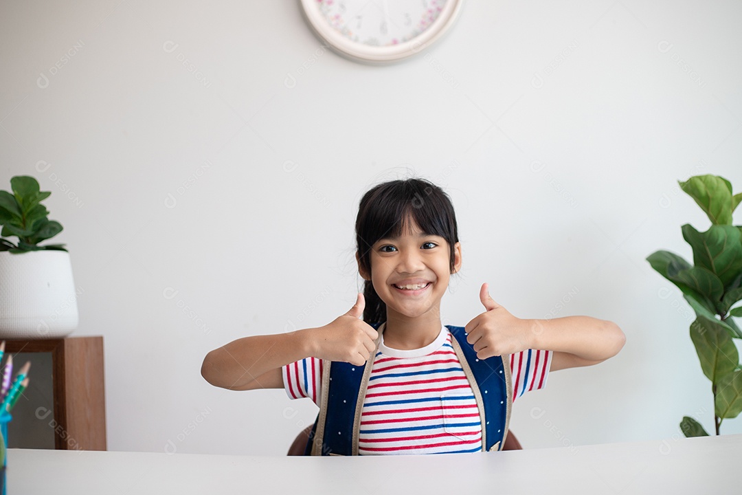 Menina asiática bonita da escola primária arrumando suas mochilas escolares, preparando-se para o primeiro dia de aula