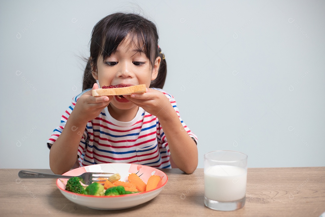 Meninas tomam café da manhã na mesa da sala de estar.