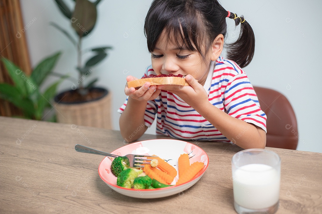 Meninas tomam café da manhã na mesa da sala de estar.