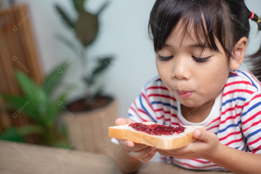 Meninas tomam café da manhã na mesa da sala de estar.