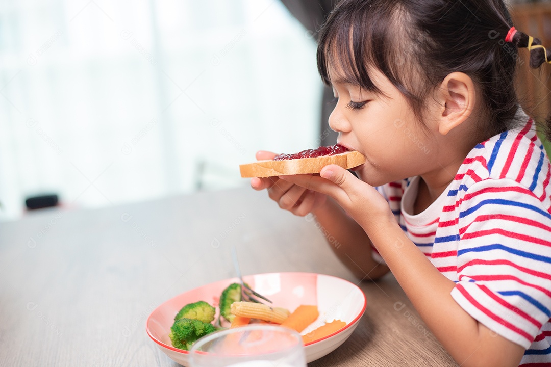 Meninas tomam café da manhã na mesa da sala de estar.