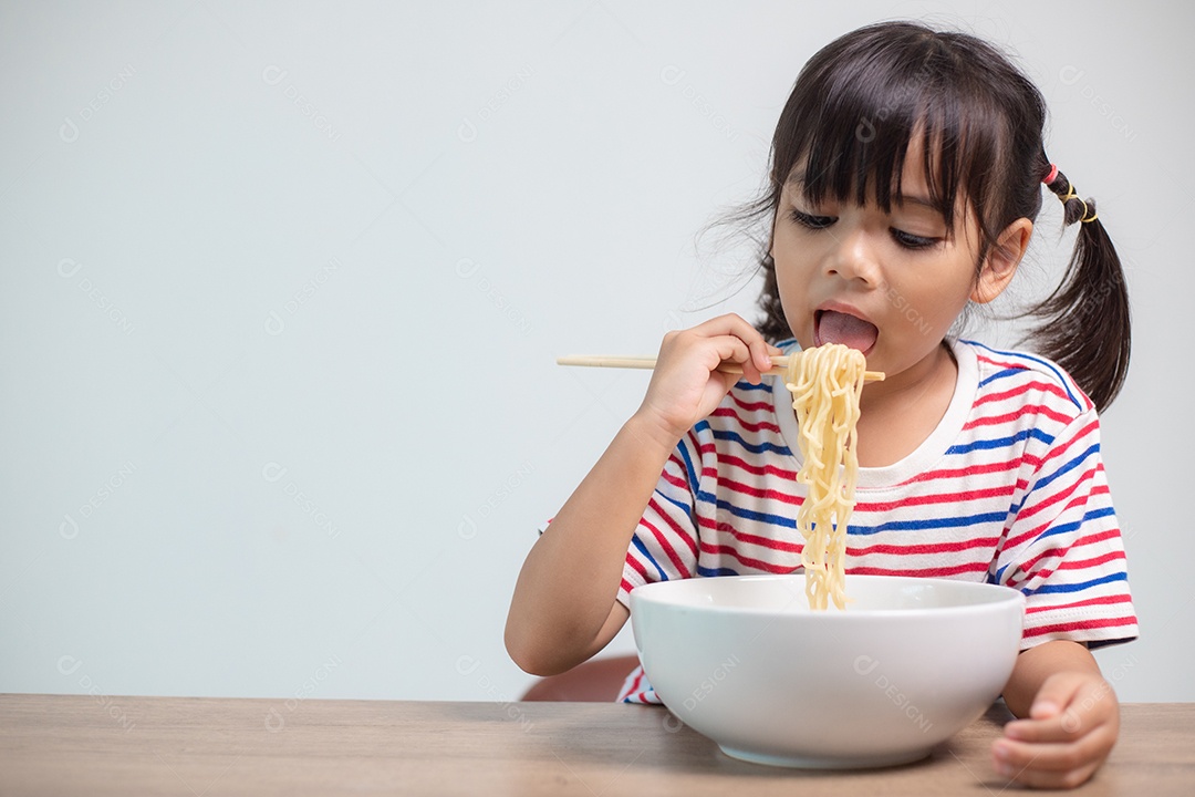 Linda garota asiática comendo deliciosos macarrão instantâneo em casa.