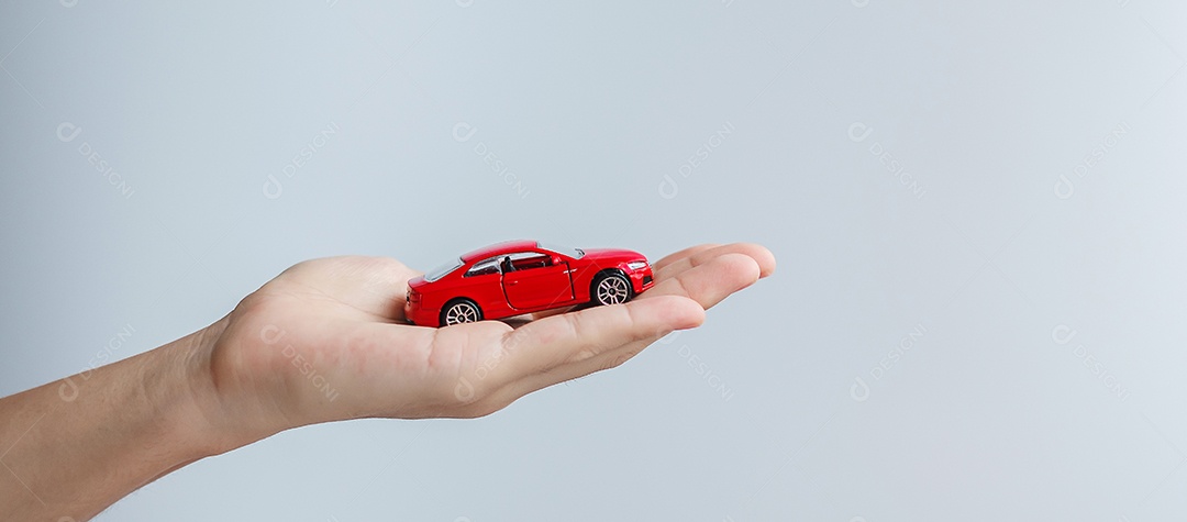 mão de empresário segurando o brinquedo do carro vermelho. Seguro de carro, garantia, aluguel, financeiro, novo e conceito de reparo