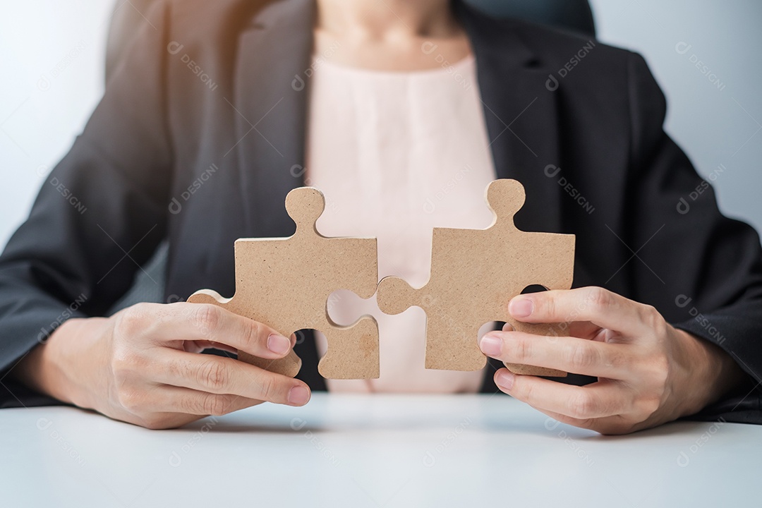 Mulher conectando peça de quebra-cabeça de casal, quebra-cabeça de madeira na mesa. Soluções de negócios, missão, sucesso, objetivos e conceitos de estratégia