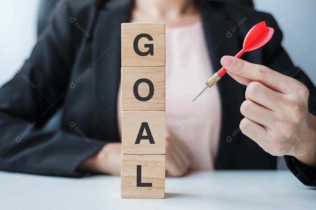 Mão segurando o dardo vermelho sobre o bloco de gol. alvo, objetivo, objetivo, liderança, conceito de negócios e marketing