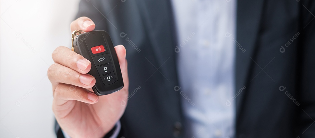 Mão de empresário segurando remoto sem chave com brinquedo de carro, caneta e documento de contrato. conceitos de compra e venda, seguro, aluguel e contrato