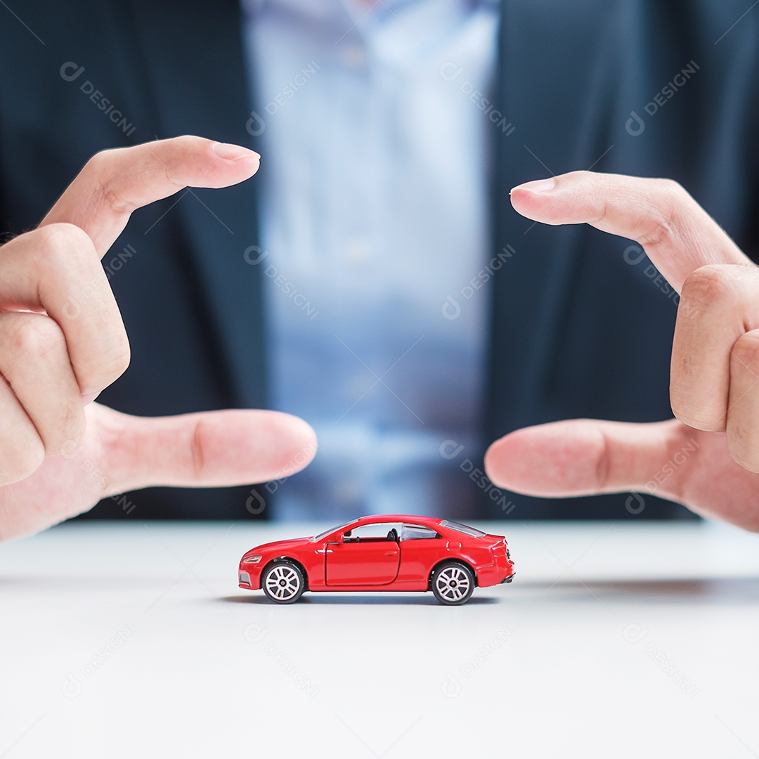 Capa de mão de empresário ou brinquedo de carro vermelho de proteção na mesa. Seguro automóvel, garantia, reparação, financeiro, bancário e conceito de dinheiro