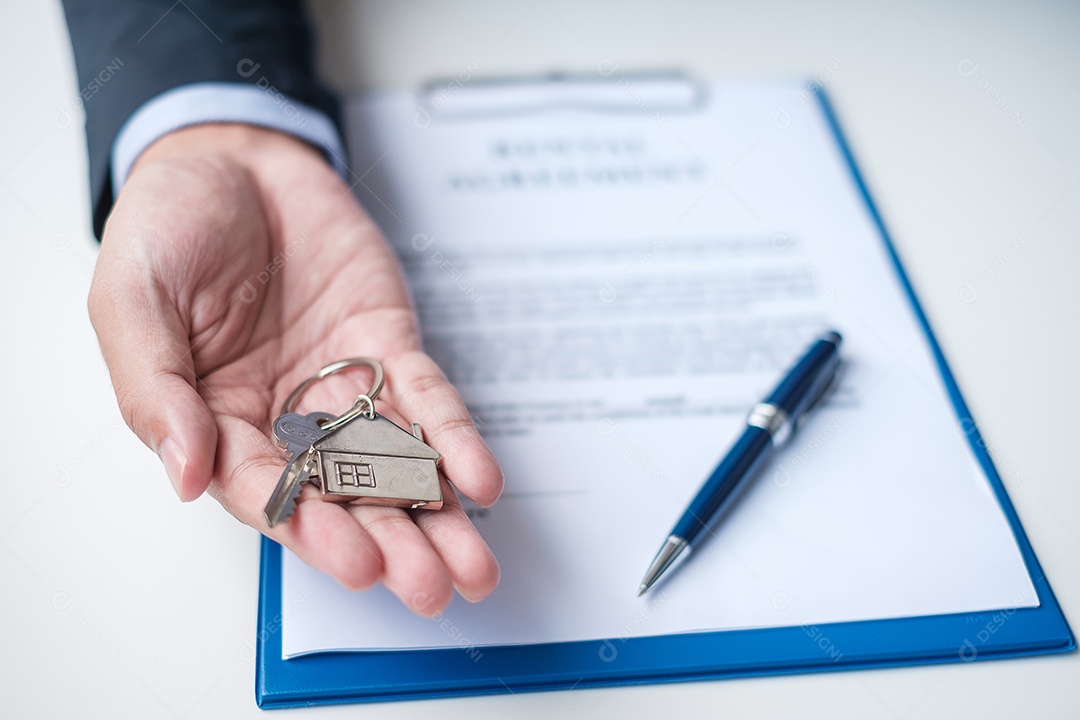 homem segurando a chave de casa durante a assinatura de documentos de contrato em casa. Contrato de contrato, imóveis, compra e venda e conceitos de seguros