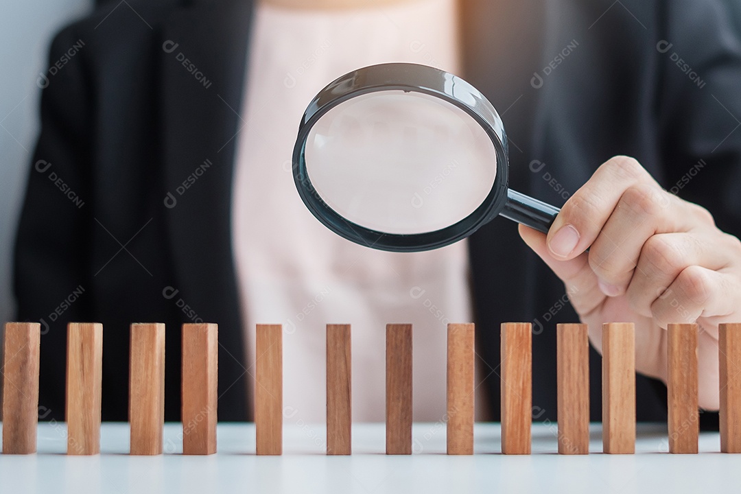 Mão de empresária segurando lupa para recrutar homem líder de madeira da multidão de blocos Gestão de recursos humanos