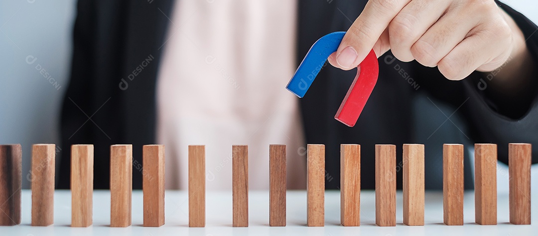 Mão de mulher de negócios segurando o ímã e puxando a figura de madeira do homem do bloco de multidão. Negócios