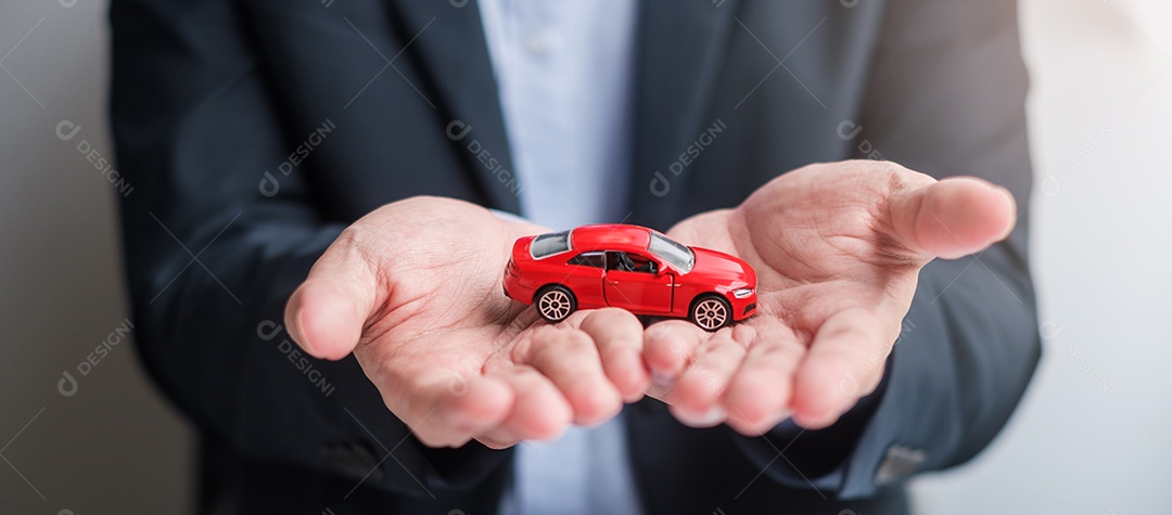 Mão de empresário segurando o brinquedo do carro vermelho com veículo sem chave, caneta e documento de contrato. conceitos de compra e venda, seguro, aluguel e contrato
