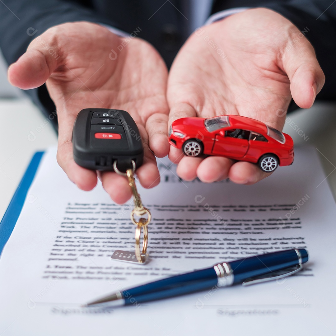 Mão de empresário segurando o brinquedo do carro vermelho com veículo sem chave, caneta e documento de contrato. conceitos de compra e venda, seguro, aluguel e contrato