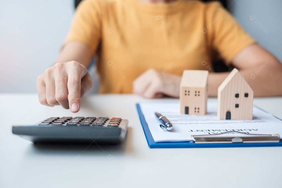 Mulher usando calculadora durante a assinatura de documentos de contrato em casa. Contrato de contrato, imóveis, compra e venda e conceitos de seguros