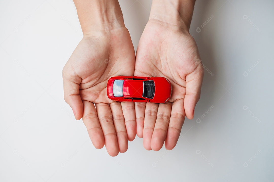 mão de empresário segurando o brinquedo do carro vermelho. Seguro de carro, garantia, aluguel, financeiro, novo e conceito de reparo