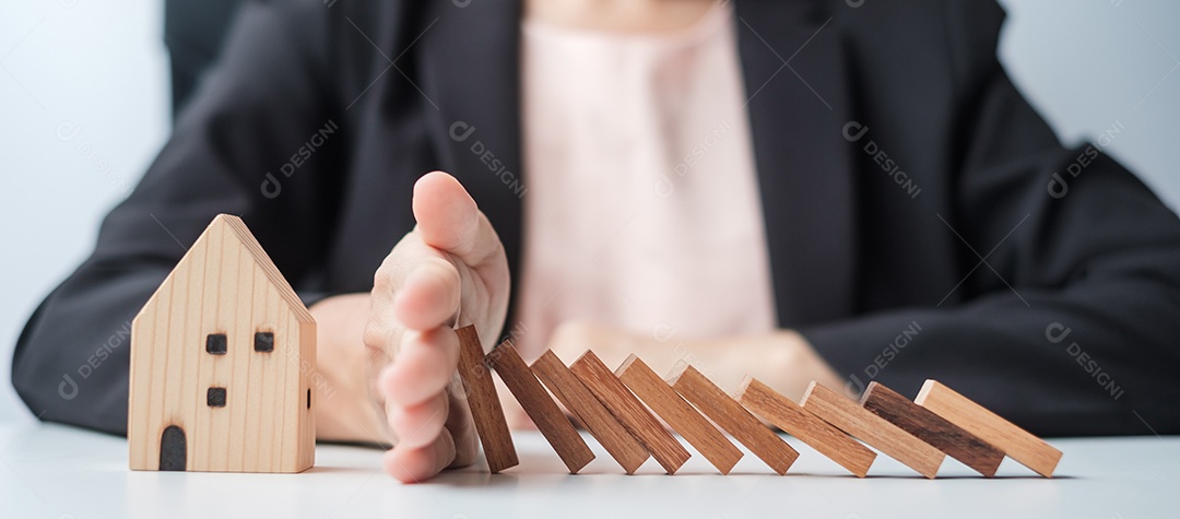 Empresário pare de cair blocos de madeira e proteja o modelo da casa. Crise, queda de negócios, risco, recessão econômica, desenvolvedor, imobiliário e conceito de propriedade