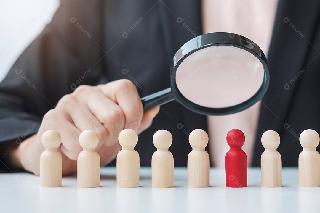 Mão de empresária segurando lupa para recrutar homem líder de madeira da multidão de funcionários Gestão de recursos humanos