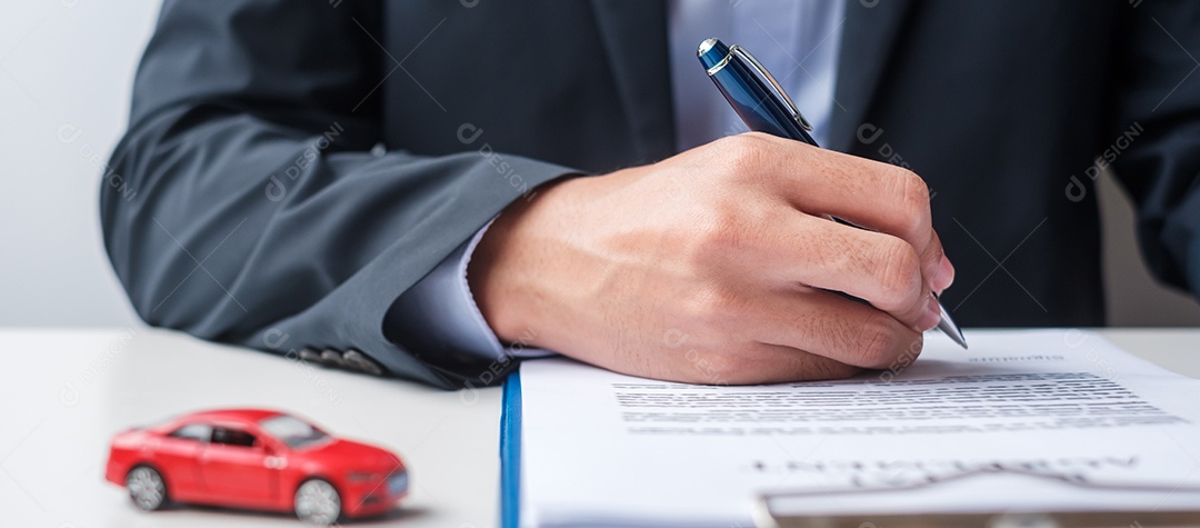 Mão de empresário segurando o brinquedo do carro vermelho com veículo sem chave, caneta e documento de contrato. conceitos de compra e venda, seguro, aluguel e contrato