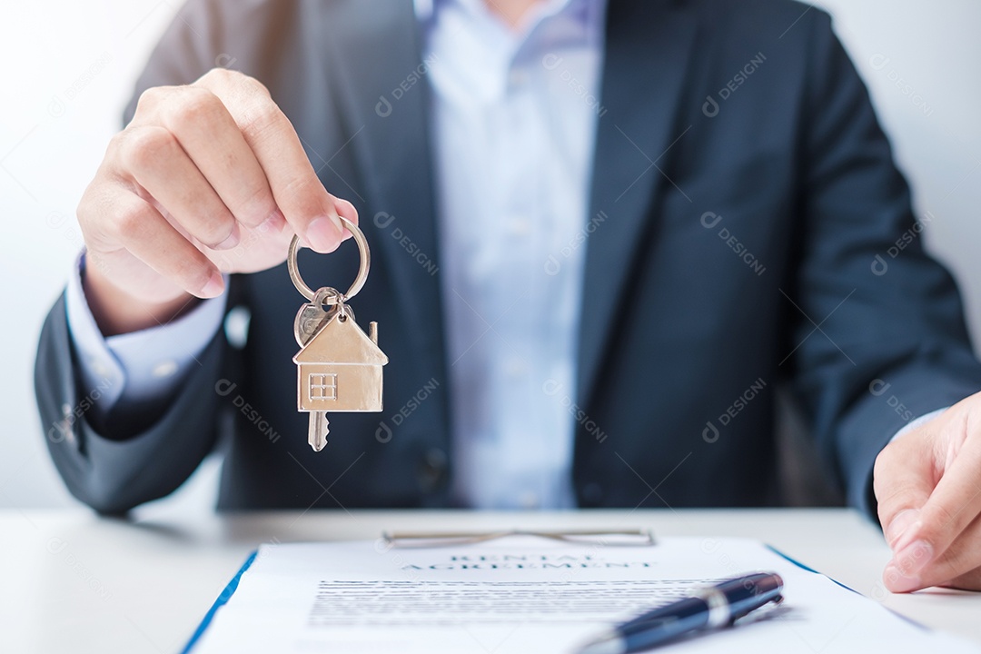homem segurando a chave de casa durante a assinatura de documentos de contrato em casa. Contrato de contrato, imóveis, compra e venda e conceitos de seguros