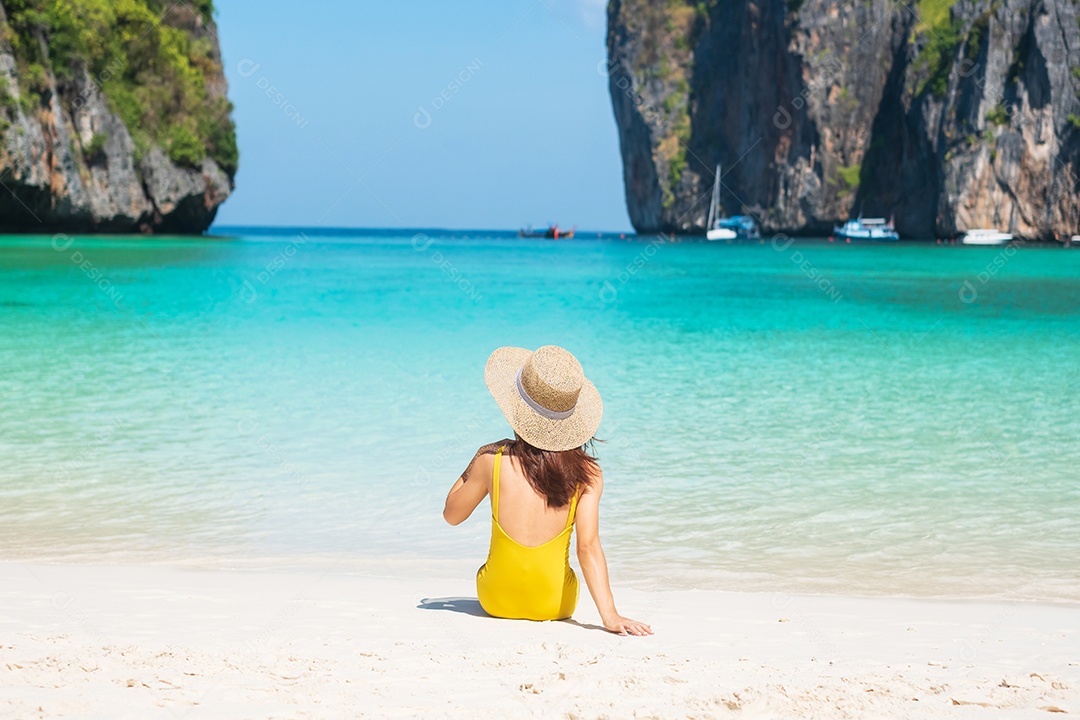 Mulher turista de maiô amarelo e chapéu, viajante feliz tomando sol na praia de Maya Bay, na ilha de Phi Phi, Krabi, Tailândia. Marco, destino Sudeste Asiático Viagens, férias e conceito de férias