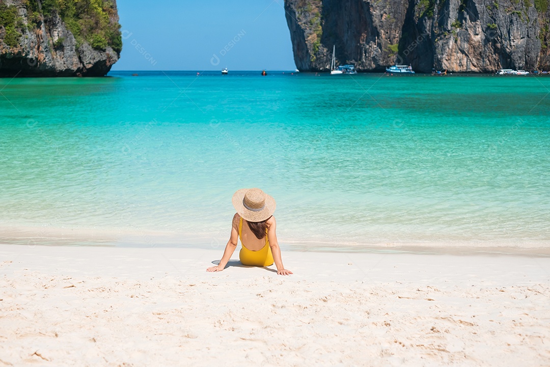 Mulher turista de maiô amarelo e chapéu, viajante feliz tomando sol na praia de Maya Bay, na ilha de Phi Phi, Krabi, Tailândia. Marco, destino Sudeste Asiático Viagens, férias e conceito de férias