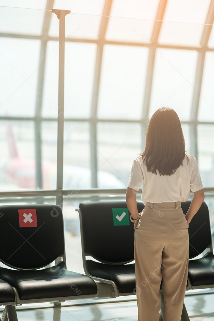 Jovem mulher usando máscara facial com bagagem andando no aeroporto, proteção contra infecção por doença de coronavírus