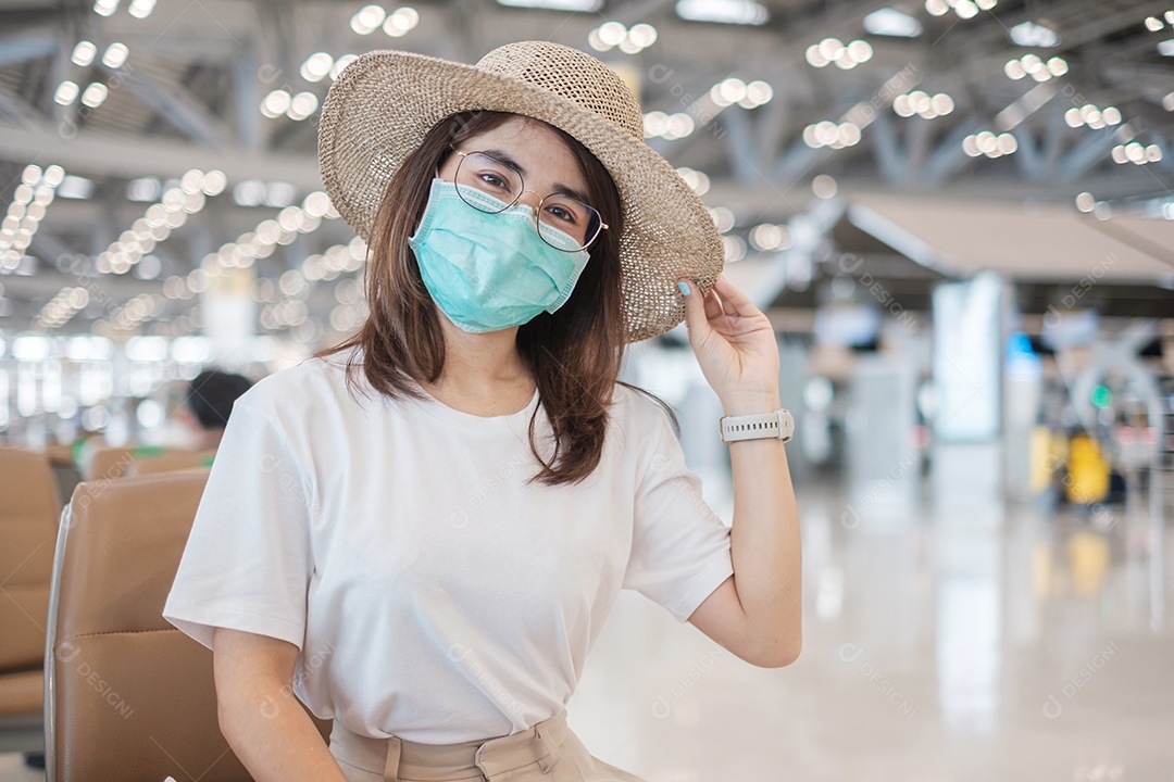 Jovem mulher usando máscara facial no aeroporto, proteção contra infecção por doença de coronavírus, viajante asiática. Hora de viajar após o conceito de dose de reforço de vacina