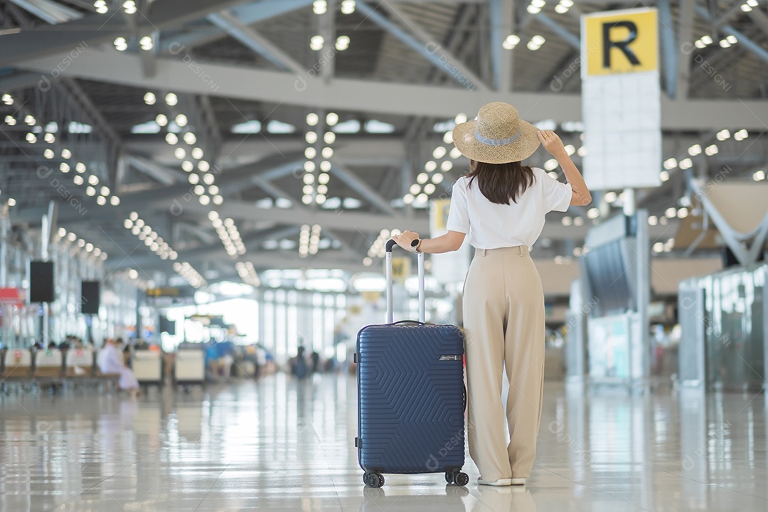 Jovem mulher usando máscara facial com bagagem andando no aeroporto, proteção contra infecção por doença de coronavírus, viajante