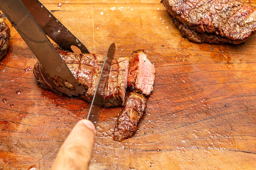 homem cortando bife de três pontas na tábua