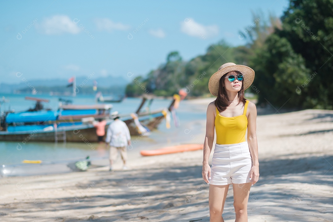 Turista de mulher de maiô amarelo e chapéu, viajante feliz na praia do paraíso nas ilhas. destino, desejo de viajar, Ásia Travel, verão tropical, férias e conceito de férias