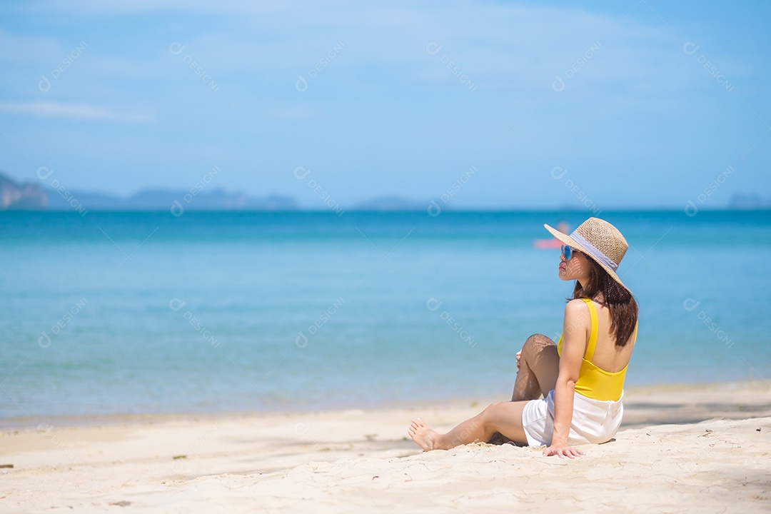 Turista de mulher de maiô amarelo e chapéu, feliz viajante tomando sol na praia do paraíso nas ilhas. destino, desejo de viajar, Ásia Travel, verão tropical, férias e conceito de férias