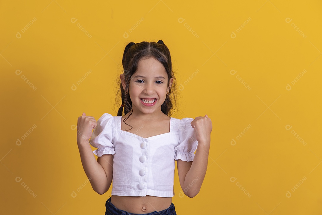 Linda criança garotinha gesto vencer sobre fundo isolado amarelo