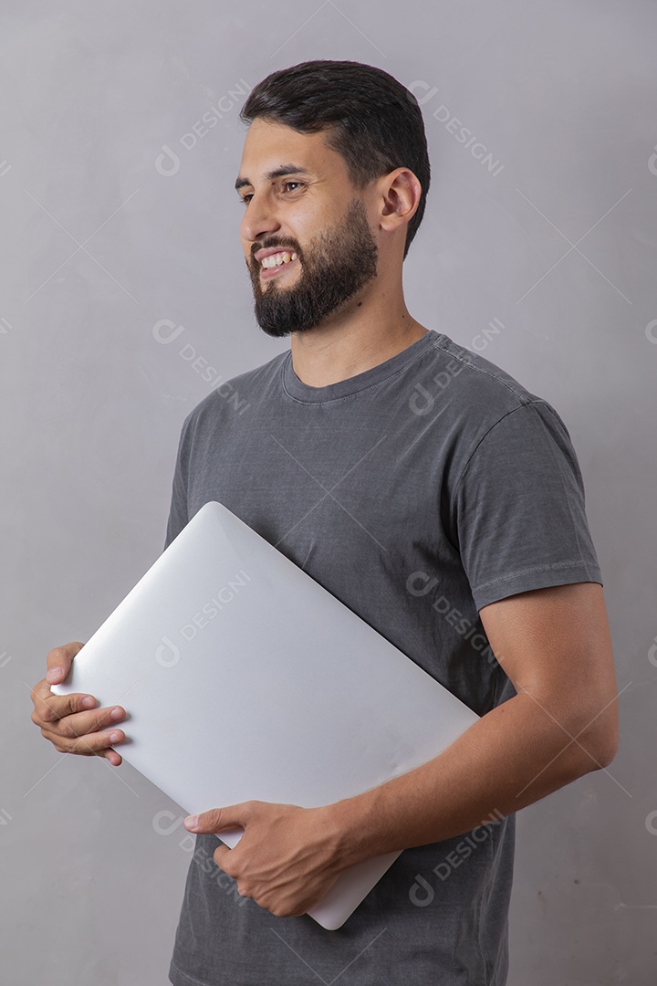 Homem jovem garoto segurando notebook sobre fundo isolado cinza