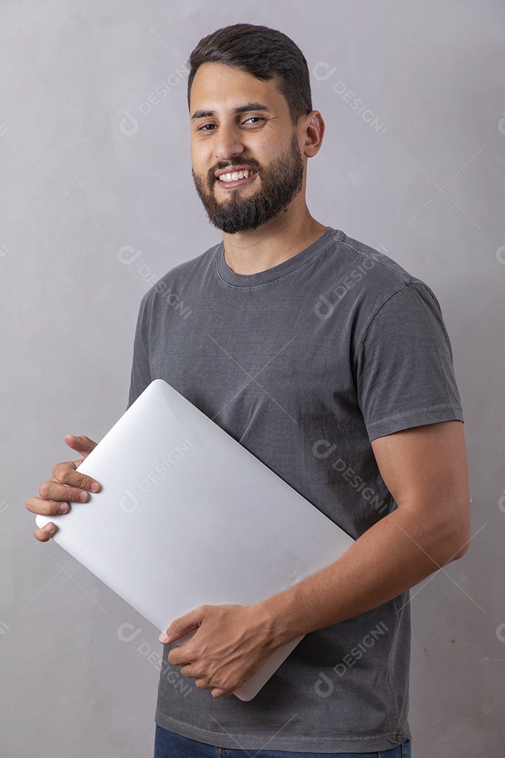 Homem jovem garoto segurando notebook sobre fundo isolado cinza