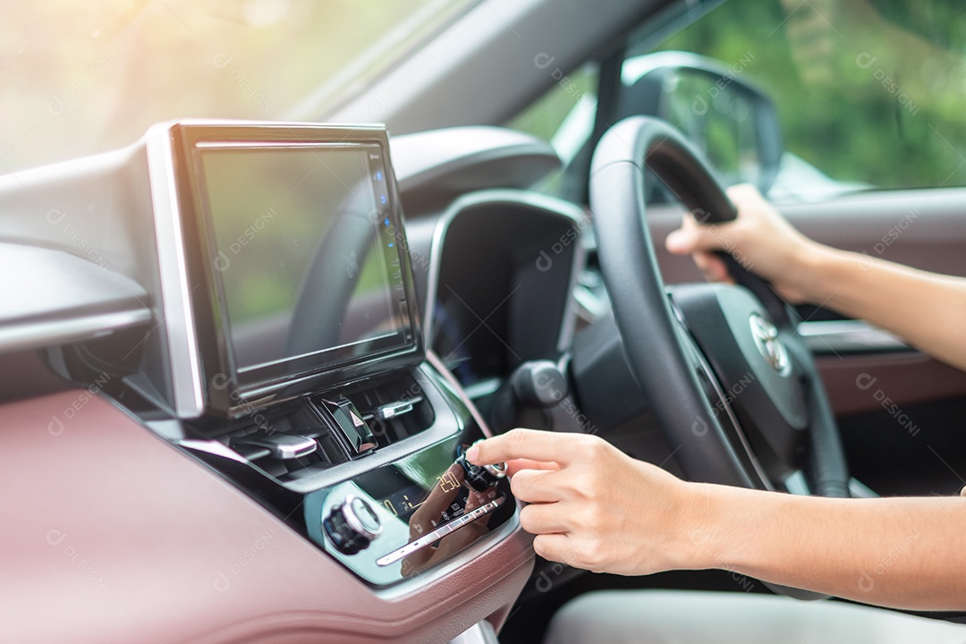 Mão de mulher ajustando a temperatura do ar que flui durante a condução do carro na estrada, sistema de refrigeração do ar condicionado