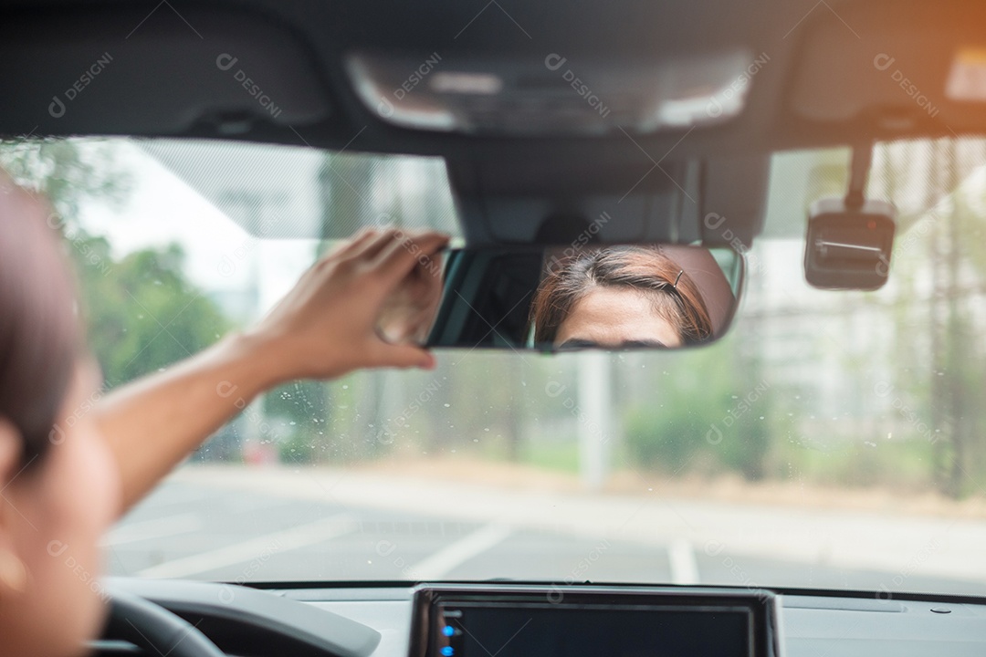 motorista de mulher ajustando o espelho retrovisor de um carro. Conceitos de transporte de viagem, viagem e segurança