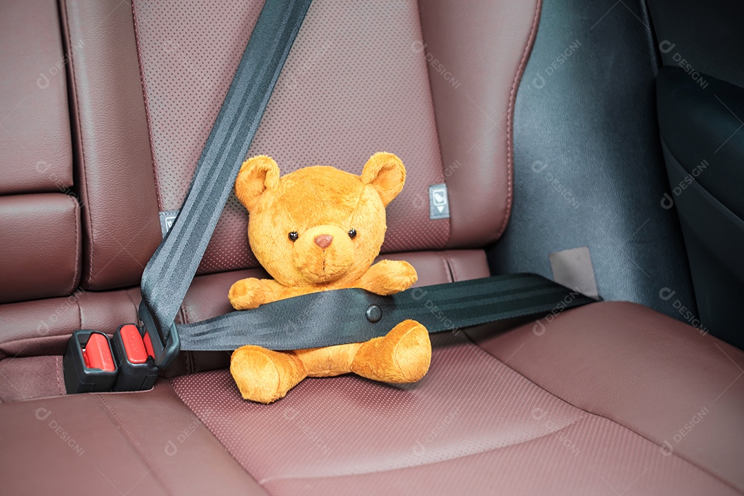 Boneca de urso amarelo prendendo o cinto de segurança durante a sessão dentro de um carro e dirigindo na estrada. Assento de carro