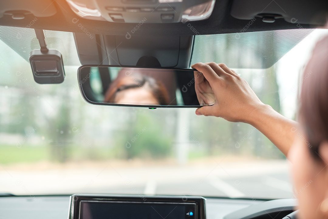 motorista de mulher ajustando o espelho retrovisor de um carro. Conceitos de transporte de viagem, viagem e segurança