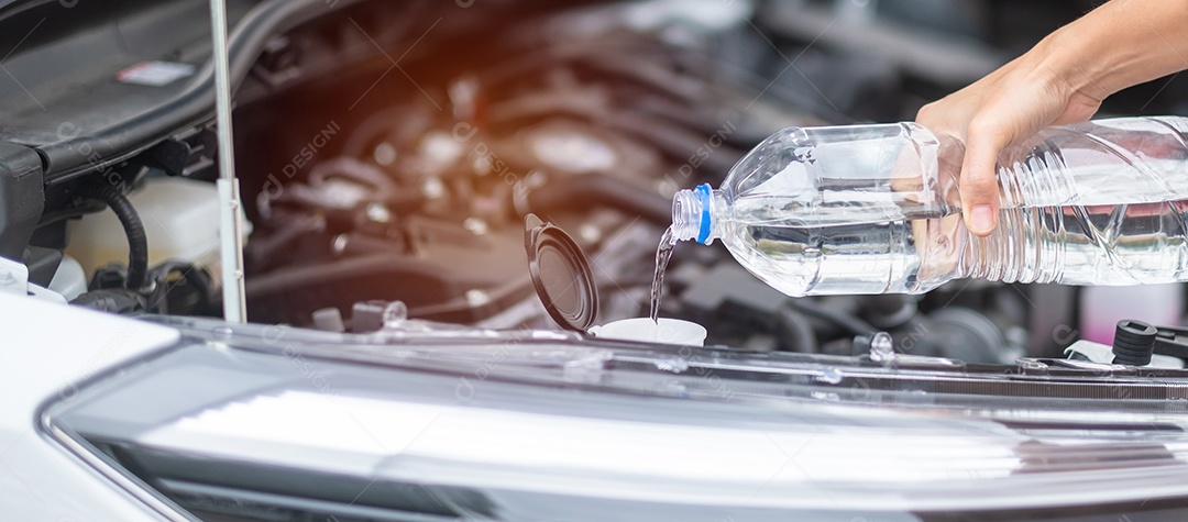 mão de mulher arquivando água pura no carro-tanque do lavador de pára-brisas. Auto-manutenção, reparação e conceito de problema