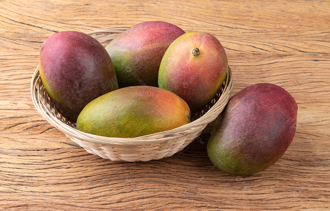 Um grupo de mangas maduras sobre a mesa de madeira.