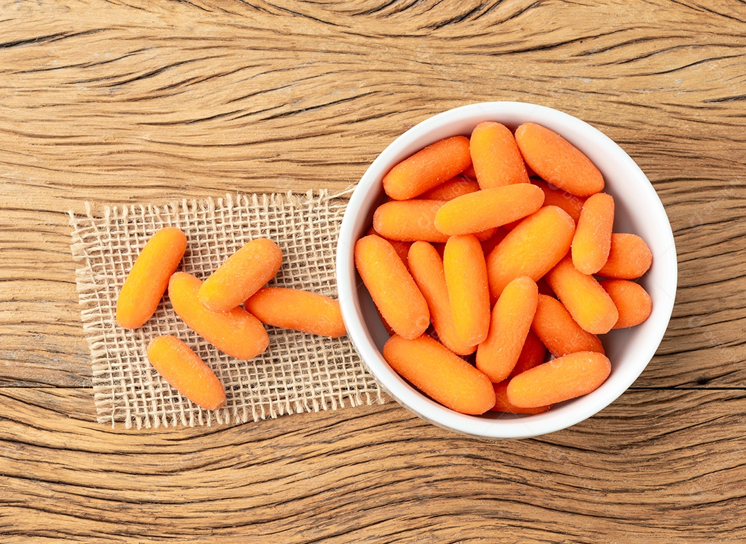 Cenouras em uma tigela sobre a mesa de madeira.