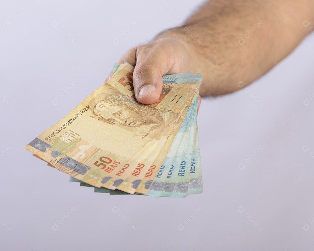 Mão segurando o dinheiro, seiscentos reais, moeda brasileira, sobre fundo branco.