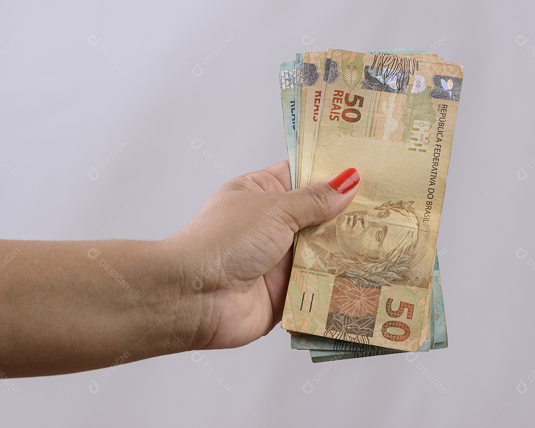 Mão segurando o dinheiro, seiscentos reais, moeda brasileira, sobre fundo branco.