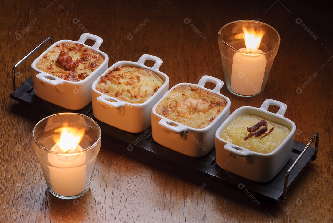 Entradas tradicionais de restaurantes brasileiros, conhecidos como escondidinho com polvo, queijo, camarão e carne.