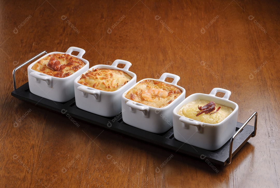 Entradas tradicionais de restaurantes brasileiros, conhecidos como escondidinho com polvo, queijo, camarão e carne.