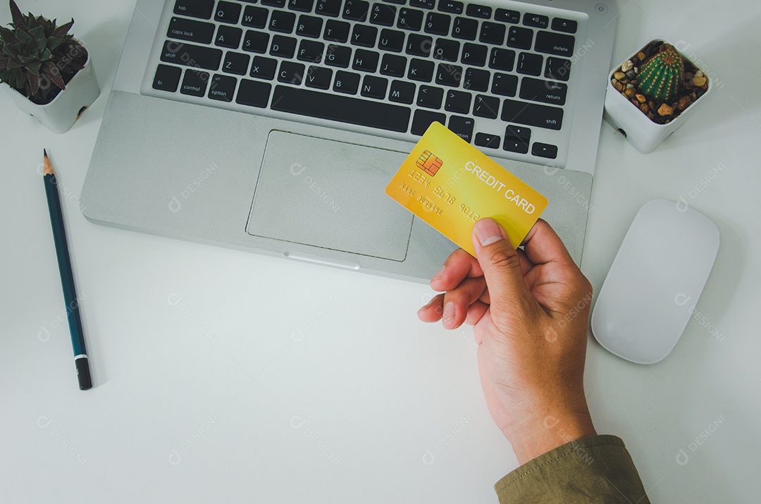 Homem de vista superior segurando um cartão de crédito na mesa Negócio de compras online, pagamento com cartão de crédito